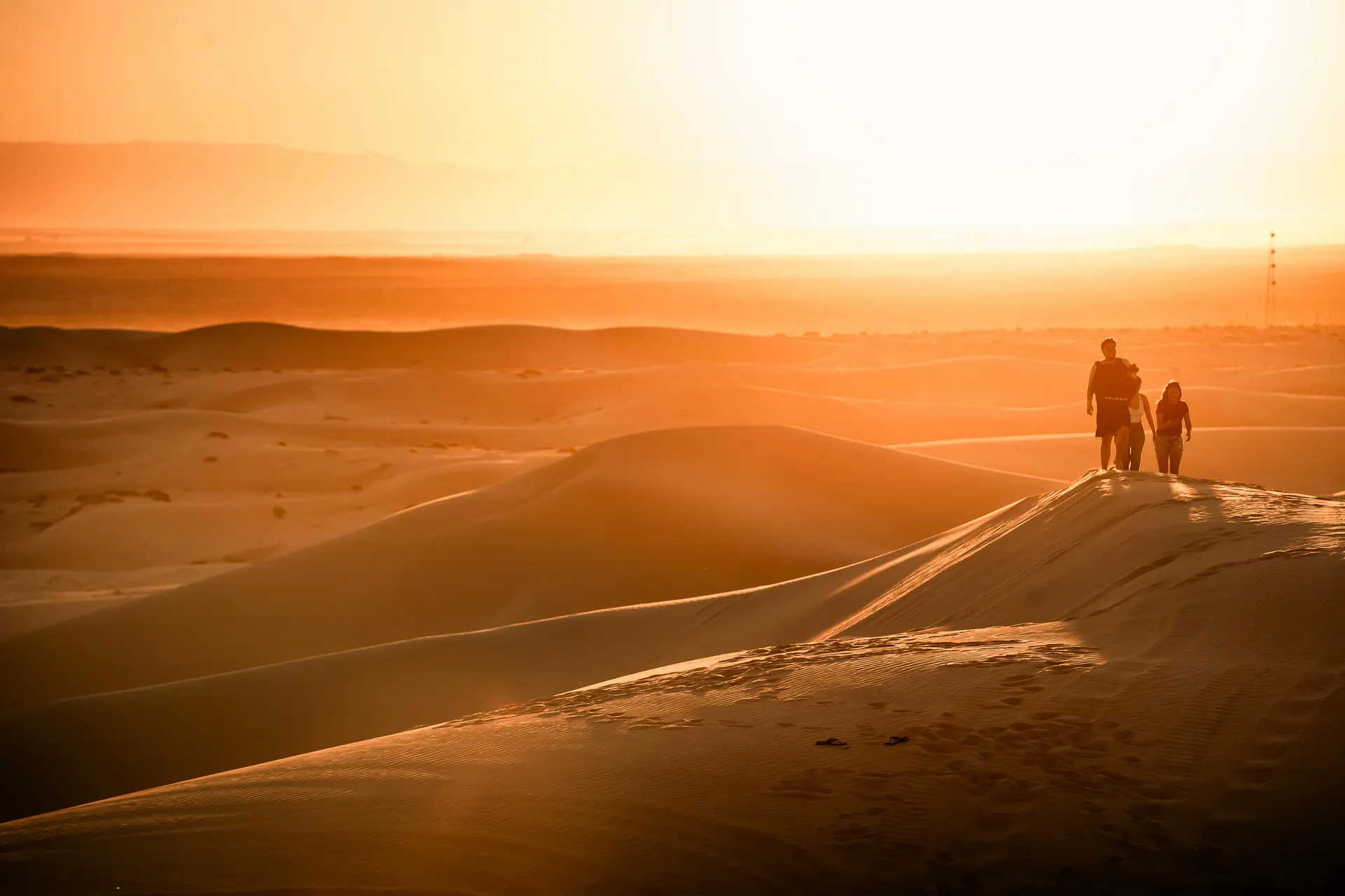 Wide desert dunes at golden hour with warm sky and premium travel mood