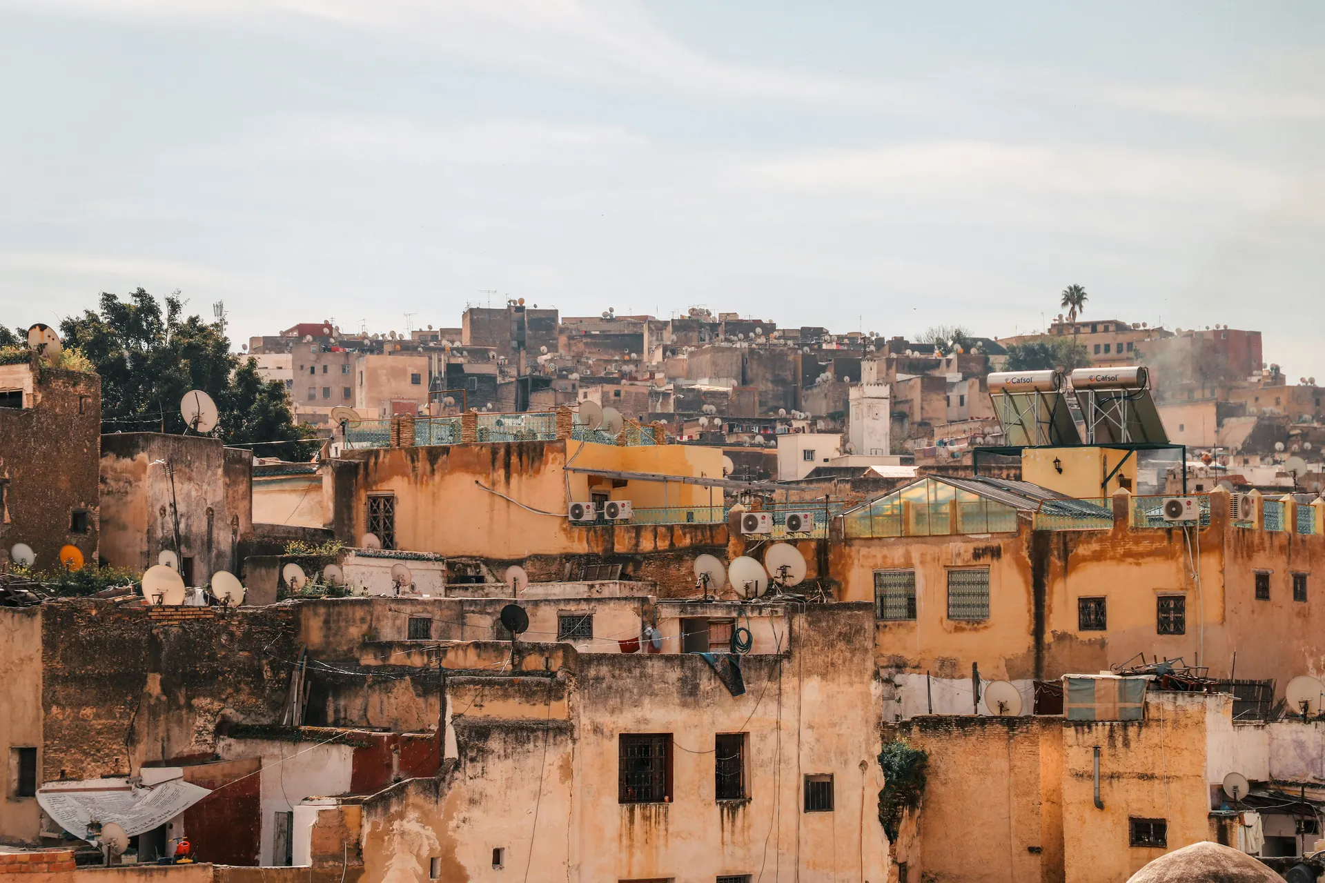 Boutique terrace overlooking a warm old city at sunset with soft premium atmosphere